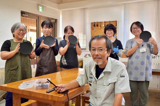 作品を持つ受講生と講師の大見謝さん（手前）