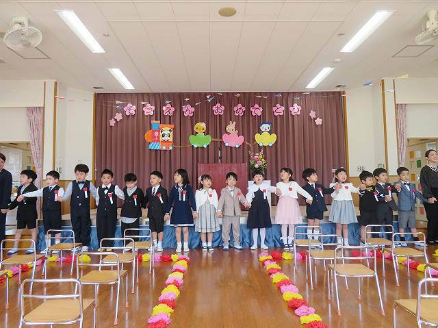 手をつないで合唱する卒園児