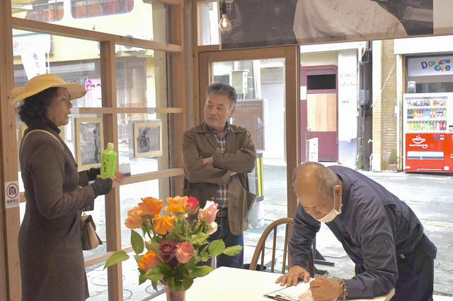 署名しながら当時の情報を提供する来場者